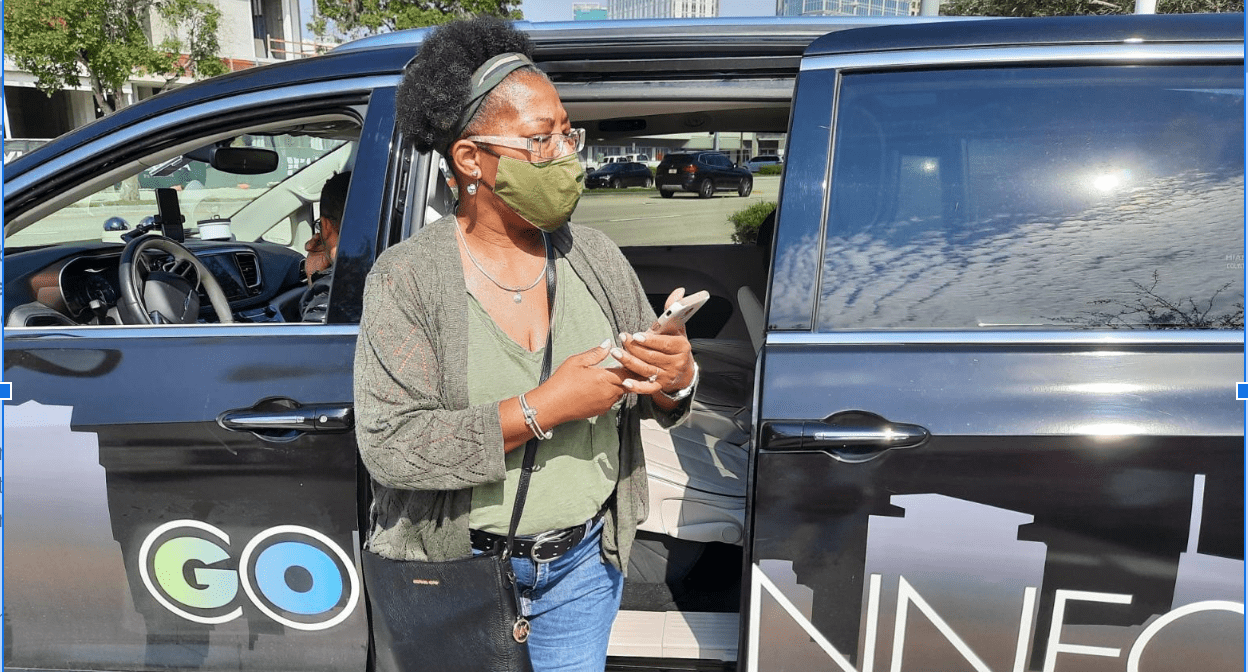 A woman wearing a mask while looking at her phone.